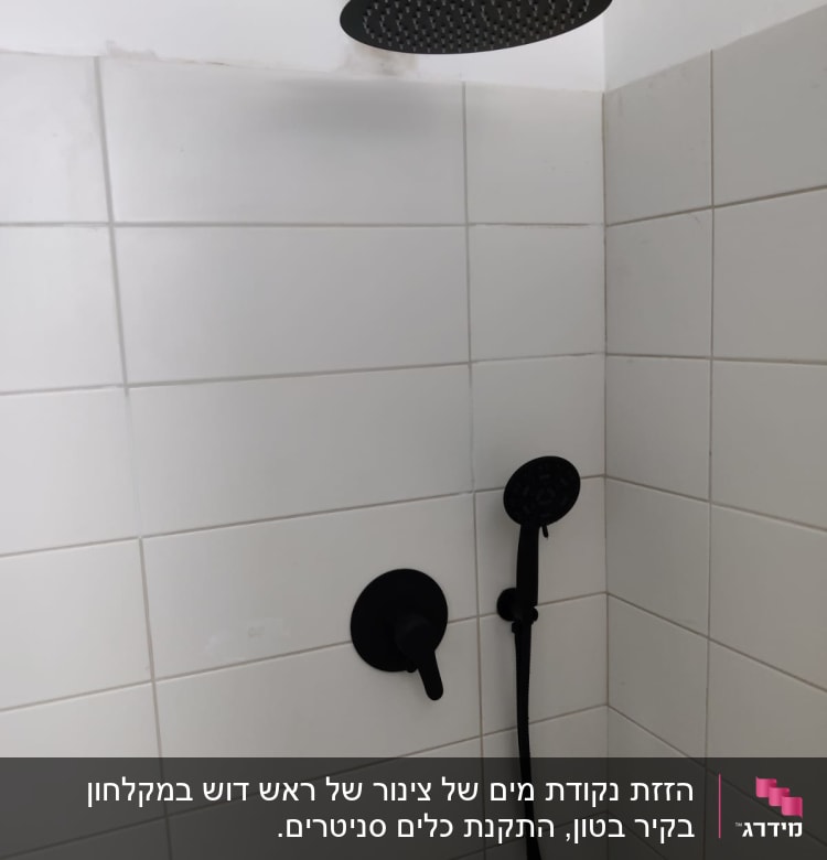 ראש מקלחת שחור עם ידית ומתג על קיר אריחים לבן